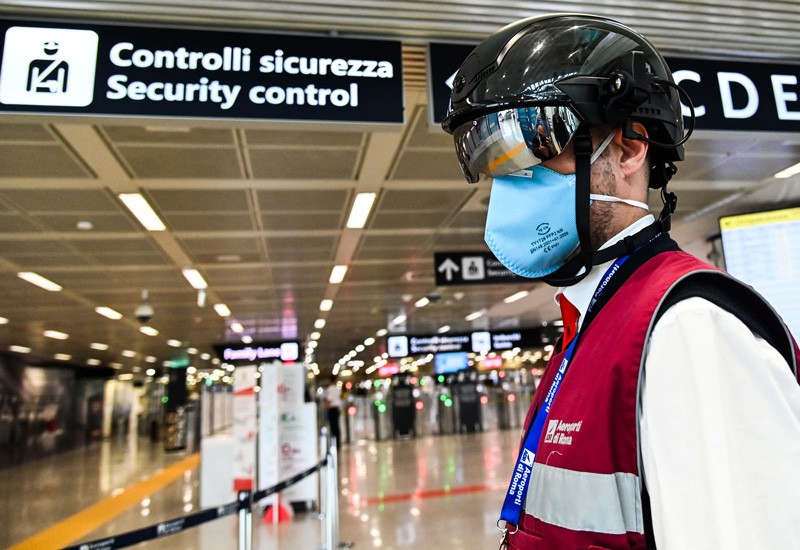 A Fiumicino airport employee wearing a "Smart-Helmet" portable thermoscanner to screen passengers and staff for COVID-19.