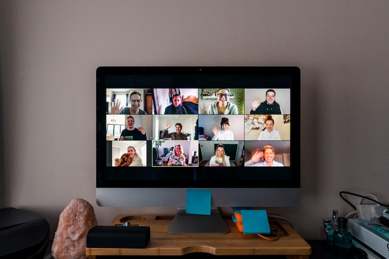 Team conference call on a computer screen in a home office.