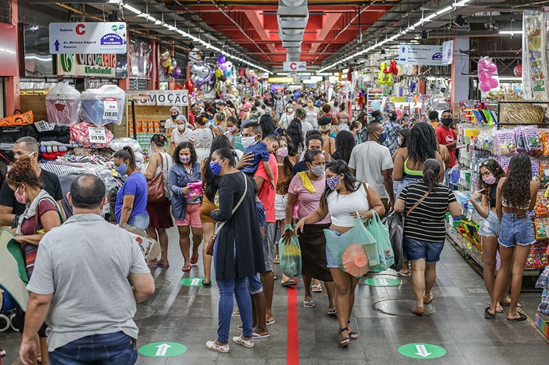 Los compradores que usan máscaras faciales caminan en un concurrido Mercadao de Madureira en Río de Janeiro, Brasil.