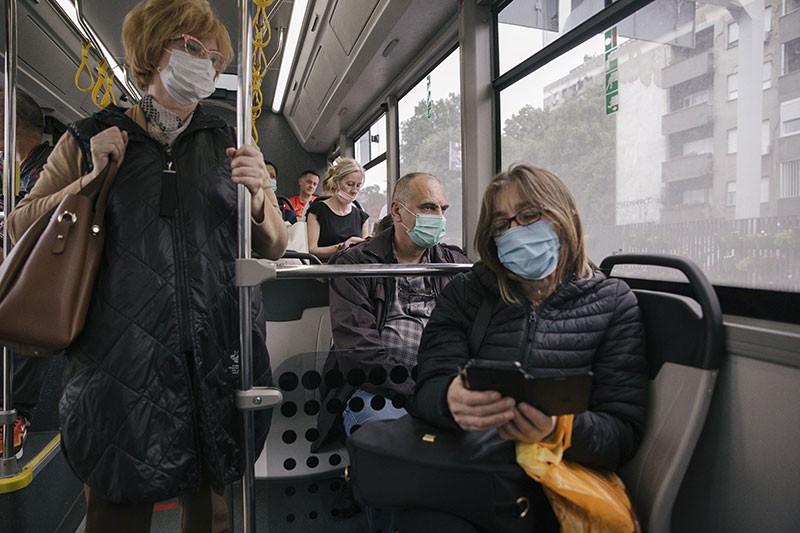 People travel on a bus wearing face masks in Belgrade.