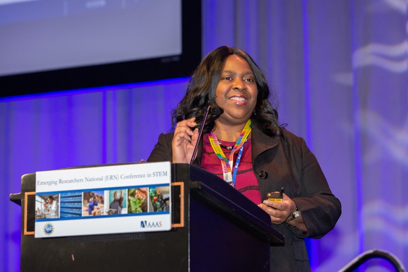 A woman speaking at a podium marked Emerging Researchers National Conference in STEM.