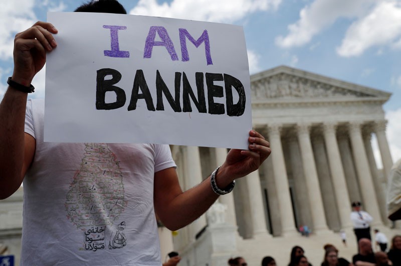 Mehrad Ansari of Iran holds a sign reading “I am banned” outside the US Supreme Court.