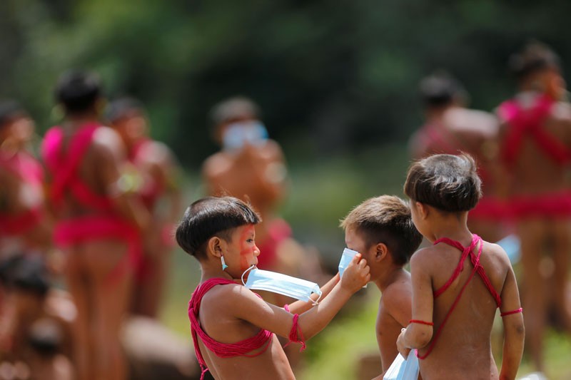 Children from the indigenous Yanomami ethnic group hold protective face masks