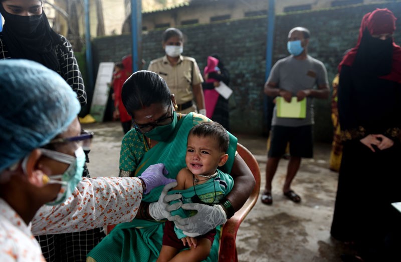 A BMC healthcare worker giving a vaccination to a small child in Mumbai