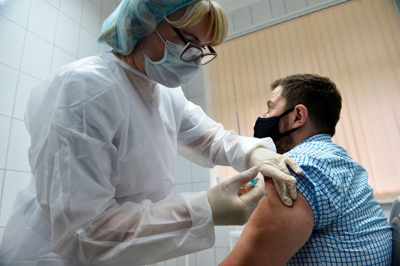 A nurse inoculates a volunteer with Russia's new coronavirus vaccine