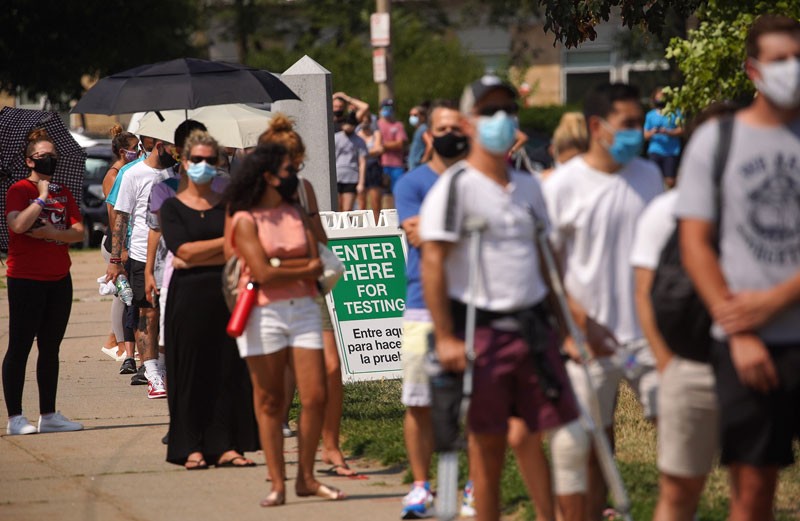 People line up to receive free COVID testing at a pop-up COVID-19 testing site