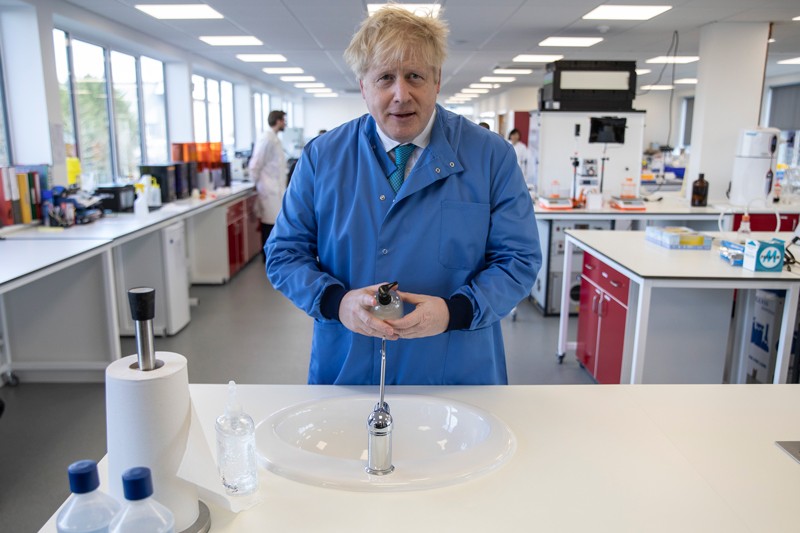 Prime Minister Boris Johnson washes his hands during a visit to the Mologic Laboratory