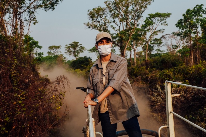 Cristina Cuiabália stands on top of a water truck riding through the Pantanal wetlands