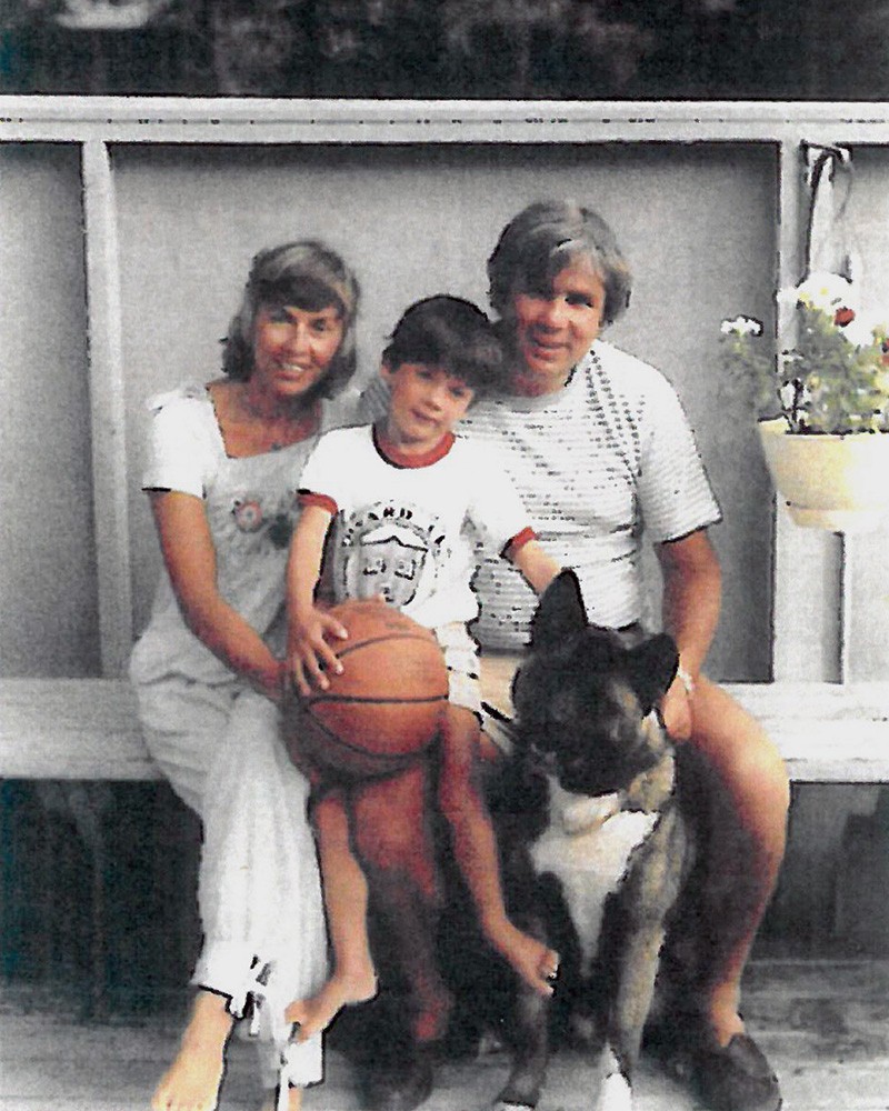 Joey, Joe and Kathy O'Donnell sit on a bench with their dog at their feet.