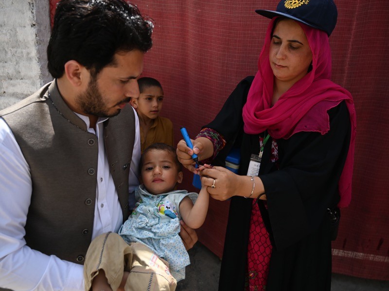 A health worker marks a child's finger after administering anti-polio drops.