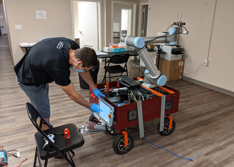 Dean Conte working on a robot in a health centre