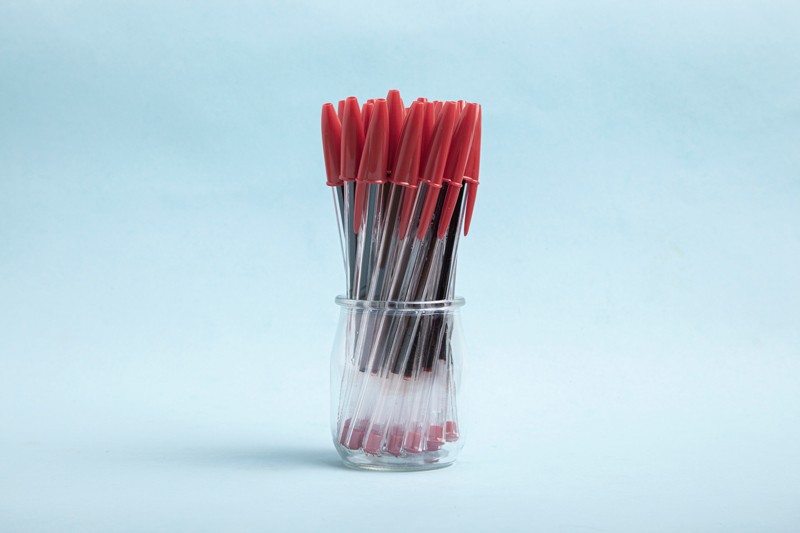 Red pens in a glass jar