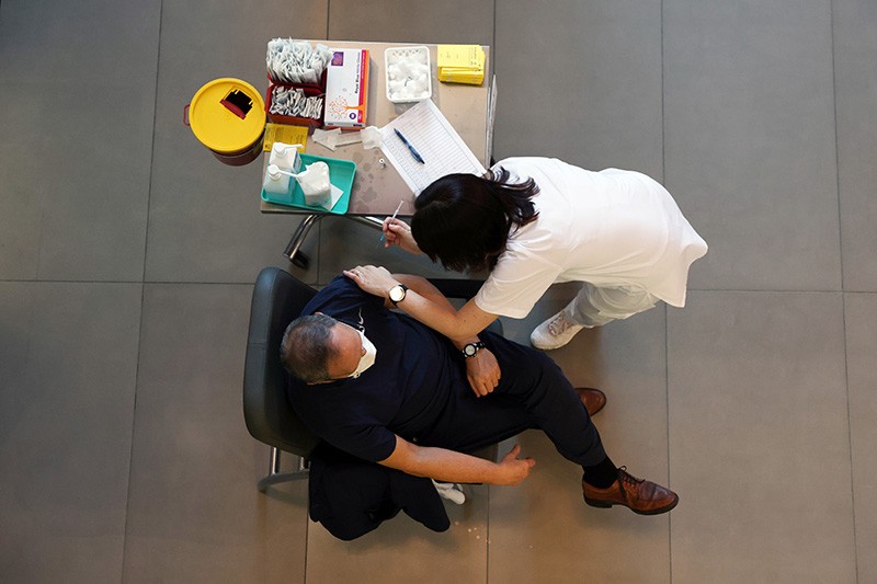 A medical worker vaccinates a man against the coronavirus disease in Israel