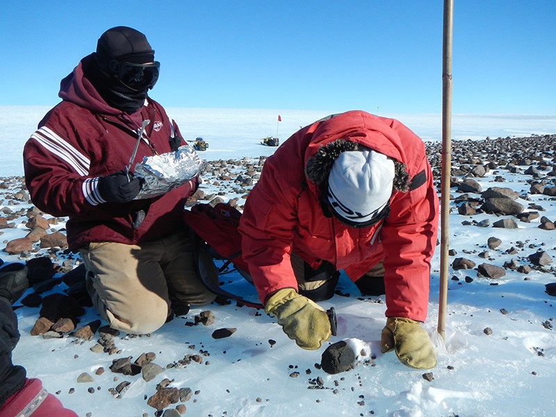 Members of the Antarctic Search for Meteorites (ANSMET) program collect a carbonaceous chondrite meteorite in Antarctica