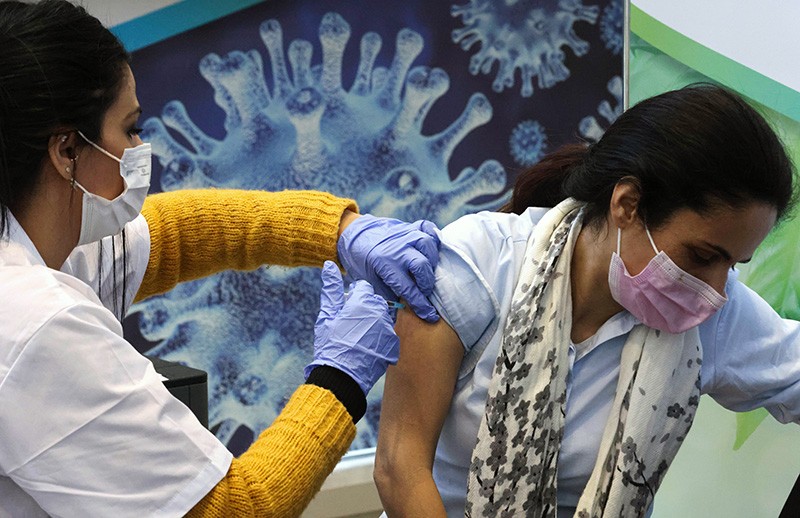 An Israeli health worker vaccinates a patient against Covid-19