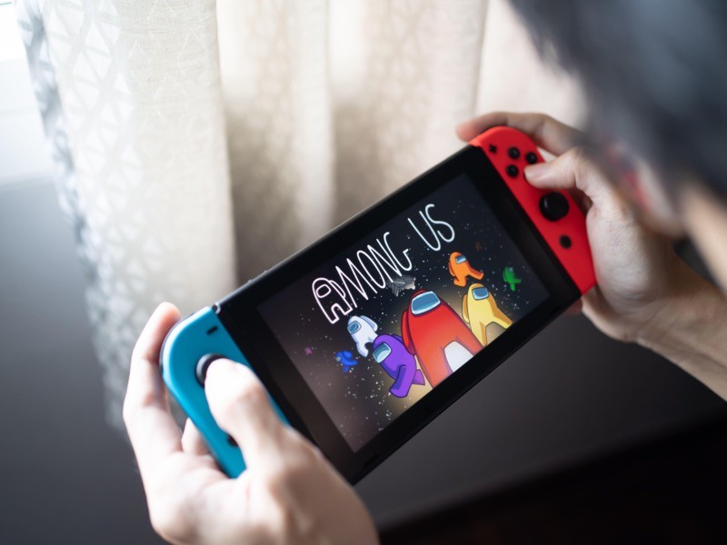 A man playing Among Us, the Best Mobile Game at The Game Awards 2020, on Nintendo Switch.