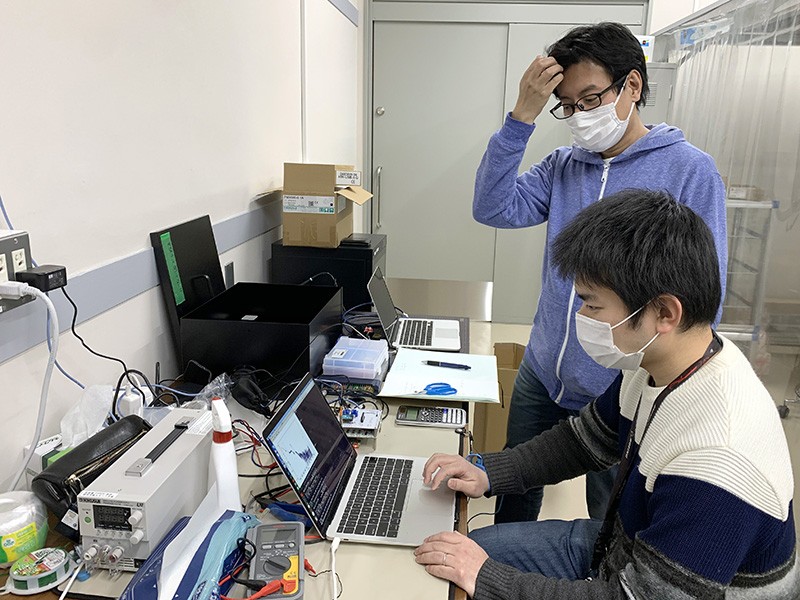 Yuuki Wada, sitting, and Teruaki Enoto, standing in their lab