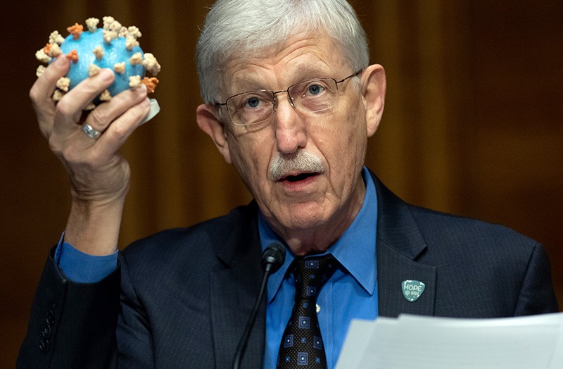 Francis Collins holds up a model of the virus SARS-CoV-2.