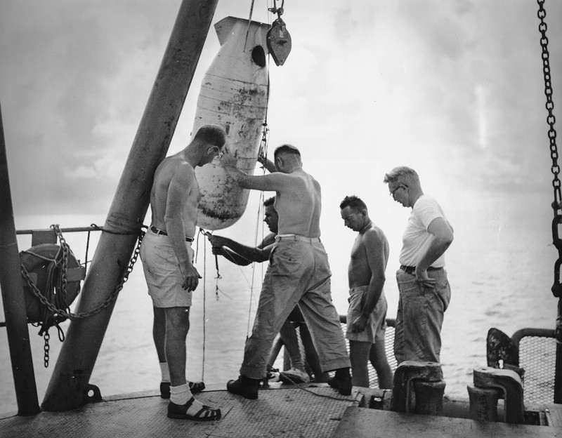 Walter H. Munk and John D. Isaacs observing an oceanographic instrument during the Capricorn Expedition