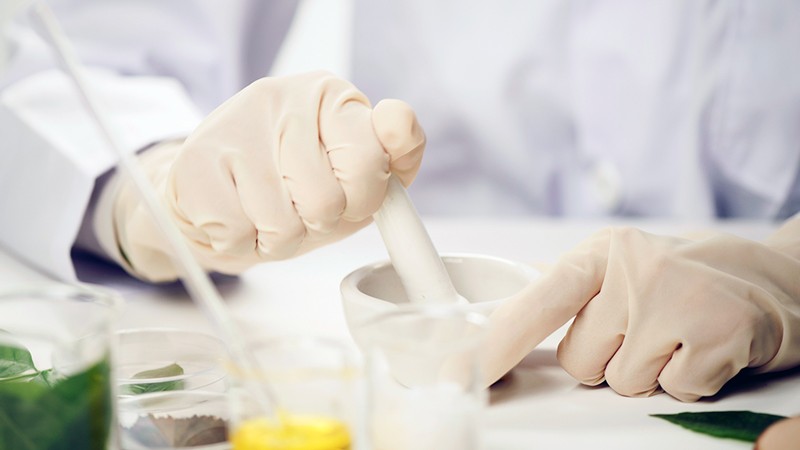 Midsection Of Scientist Making Medicines On Table In Laboratory.