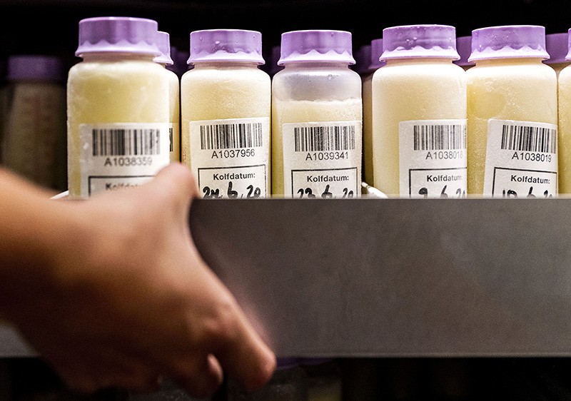 A staff member at the breast milk bank of the VUmc carries a box with bottles containing breast milk in Amsterdam, in 2020