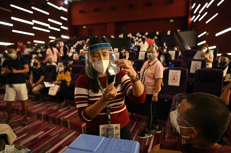 A health worker prepares a COVID-19 vaccine at a vaccination centre at a movie theatre in Manila, Philippines.