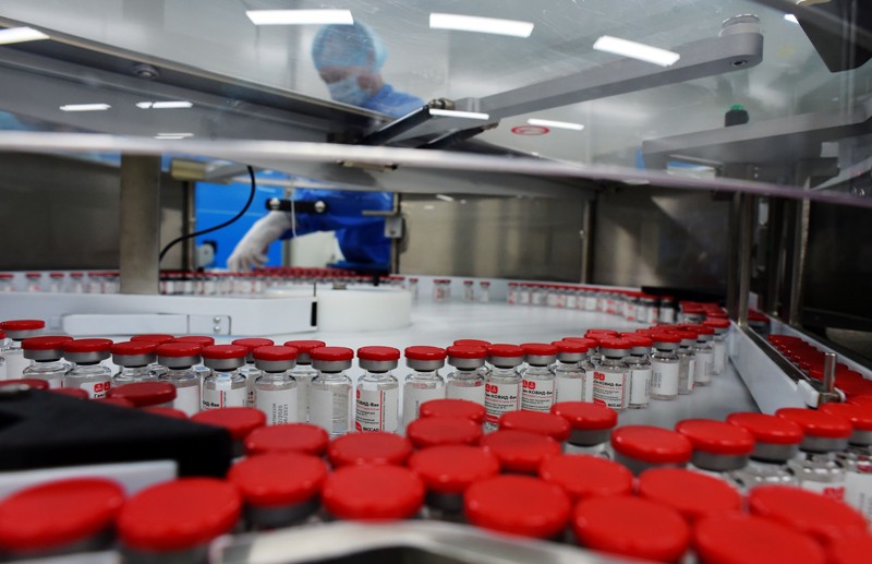 Vials of the Sputnik COVID-19 vaccine pass along a production line at a manufacturing facility in Russia