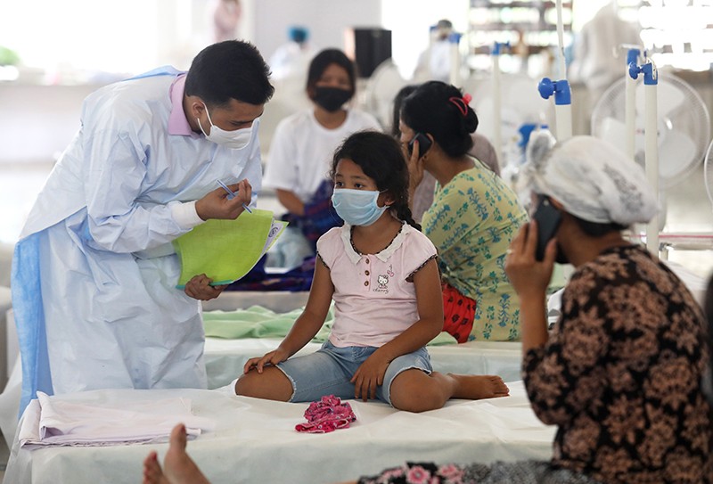 A doctor tends to a child who may have COVID-19, in a heath care centre in New Delhi, India