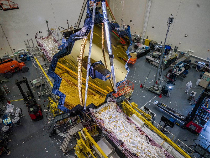 Hexagonal gold mirrors suspended in a clean room.