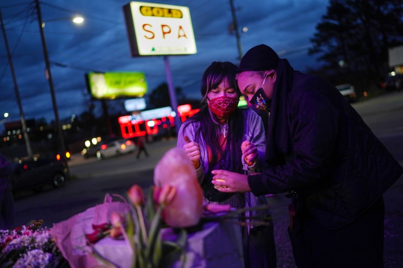Mourners place a candle at a makeshift memorial outside Gold Spa, Georgia, US, where eight people were shot and killed