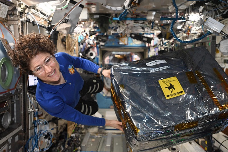 Astronaut Christina Koch unloads new hardware from a box aboard the International Space Station in 2020.
