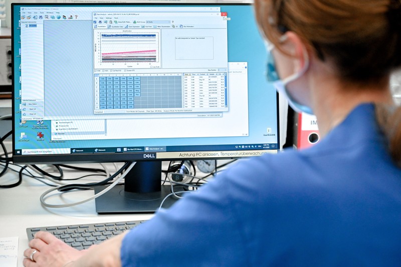 A molecular geneticist is evaluating a test for SARS-CoV-2 coronavirus on a computer