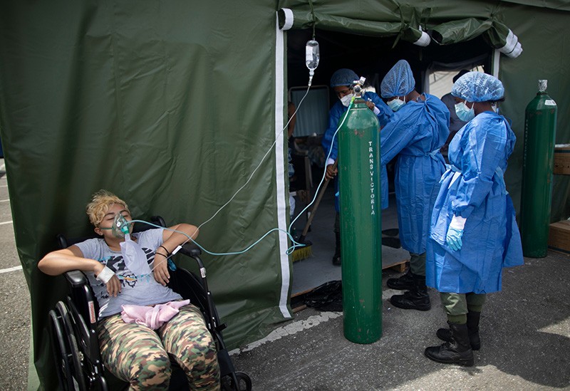 A patient with COVID-19 receives oxygen at a field hospital in a parking lot in Caracas, Venezuela.