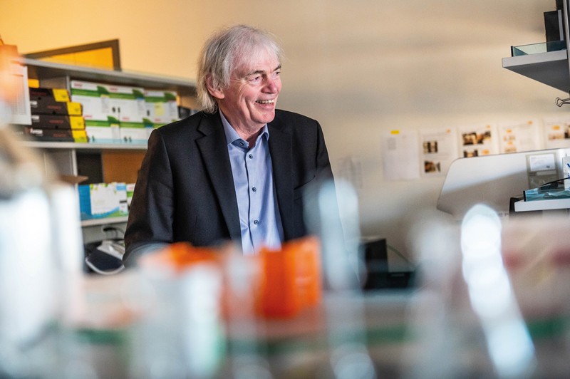Pieter Cullis stojící a usmívající se v laboratoři