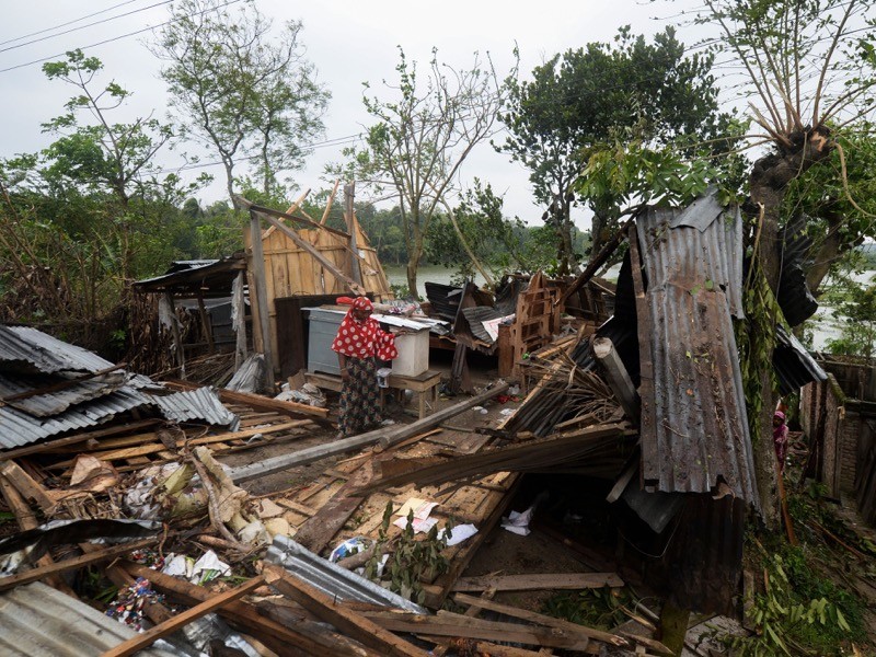 A woman stands amidst the debris of her house damaged by cyclone Amphan in Satkhira, India.