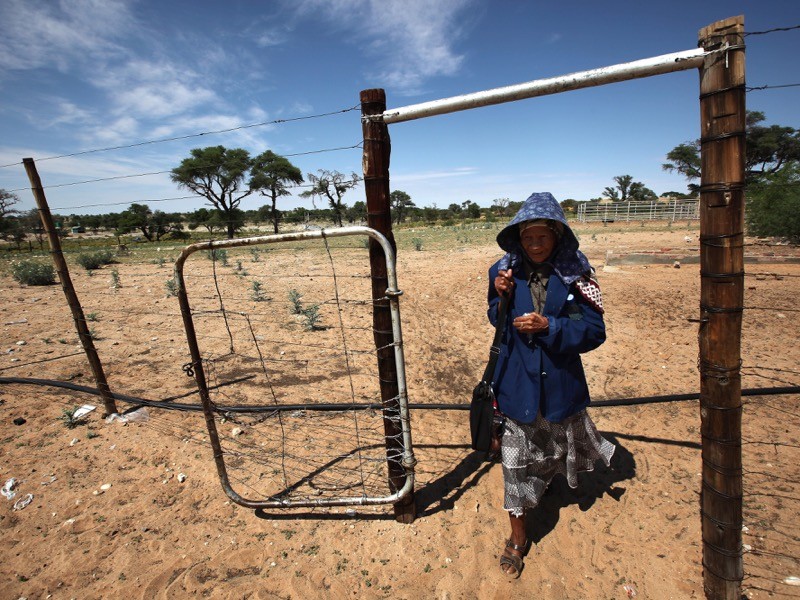 San Bushwoman Una 82, walks through her community in the Southern Kalahari desert, South Africa.