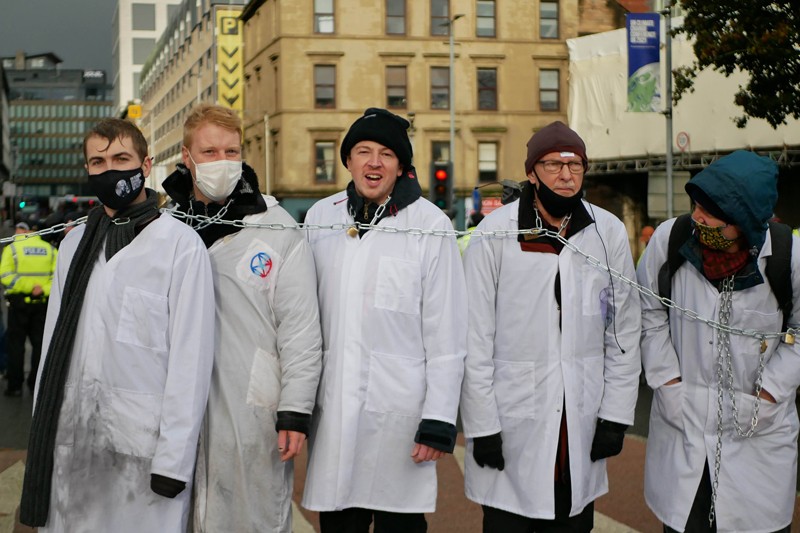 Protesters wearing white lab coats demonstrate whilst chained together during COP26 in Glasgow