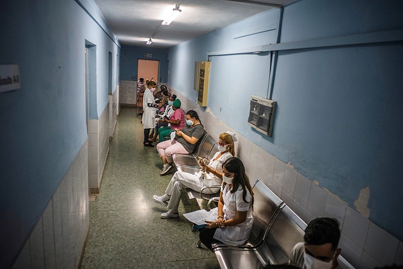 Health workers wait in a hallway for a dose of the Soberana-02 COVID-19 vaccine, during Phase III trials, in Havana, Cuba.