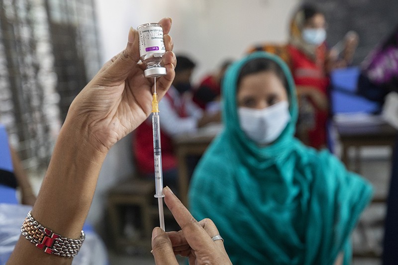 Residents of Dhaka, Bangladesh wait to get the Covid-19 vaccine from healthcare workers.