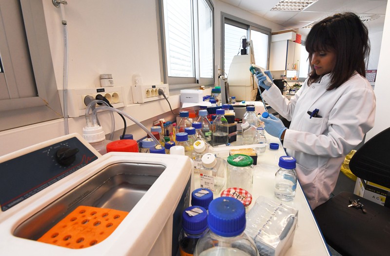 A woman works in a lab at the Cancer Research Center of Marseille