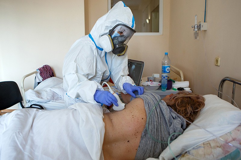 A doctor in PPE investigates a COVID-19 patient's lungs by ultrasound in a hospital in Ukraine.