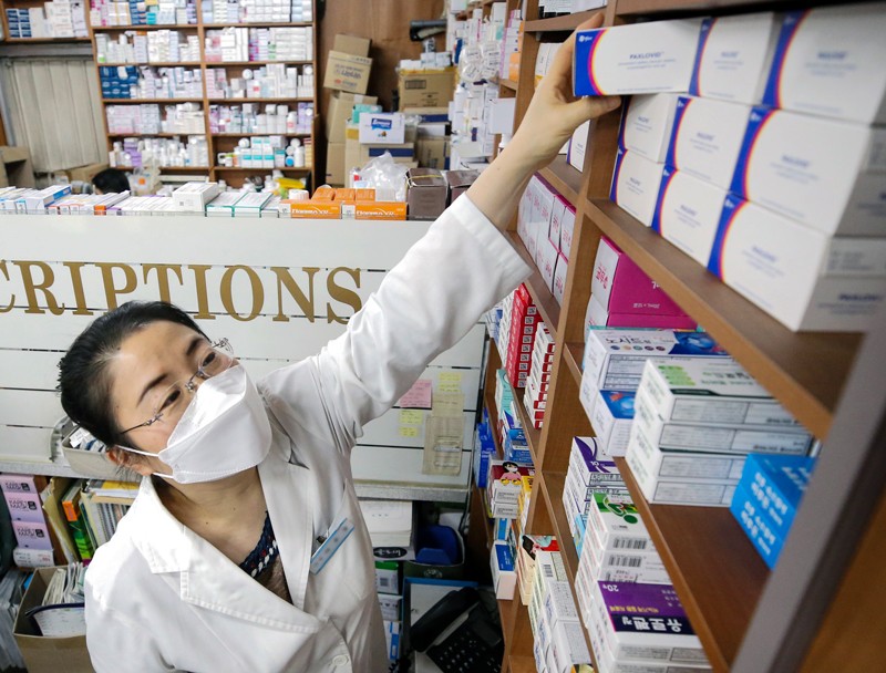 A pharmacist stocks shelves with Pfizer's oral pills against COVID-19, Paxlovid, in Seoul, South Kora