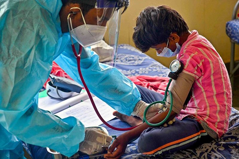 A young boy has his blood pressure checked by a doctor at a COVID care & quarantine centre in Karnataka, India.