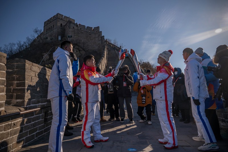 Torchbearers pass the Olympic Flame to one another on the Great Wall of China