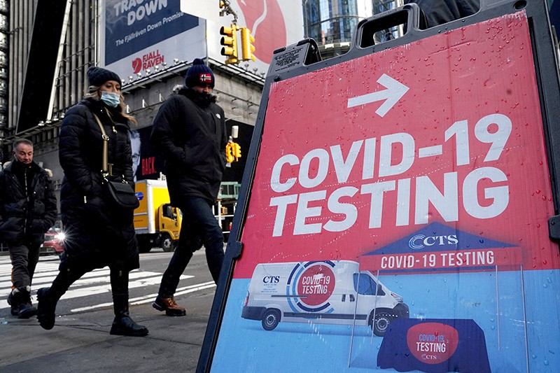 People walk past a COVID-19 testing sign on the street, during the COVID-19 pandemic in New York City, New York, U.S.
