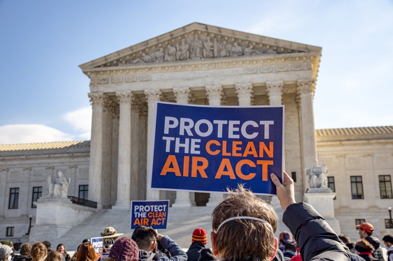 Protesters hold up signs reading 'Protect the clean air act' in front of the U.S. Supreme Court building in Washington D. C.