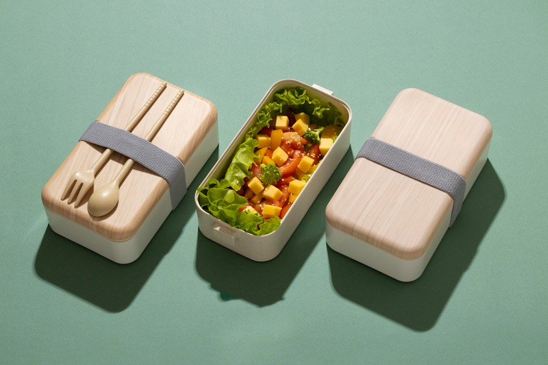 Top view of Japanese bento box on green background