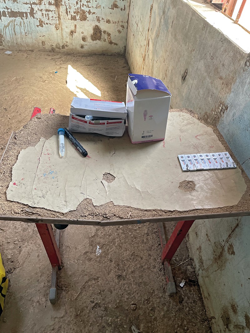 A box of tests sits on a dilapidated table in an empty room