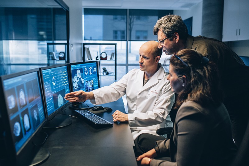 Sylvain Martel and his colleagues review information on a bank of computer screens