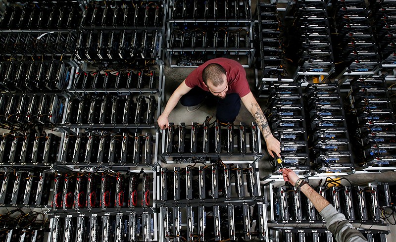 Two employees work on bitcoin mining computers at Bitminer Factory in Florence, Italy, April 6, 2018.